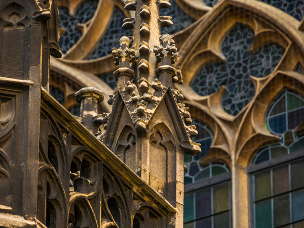 Fotografía exterior de la aguja de la torre con las ventanas de la catedral al fondo